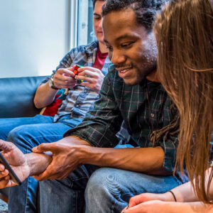 Three people chatting and looking at cell phone screen