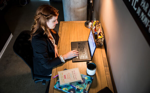 Anna-Vija McClain working on laptop in professional office