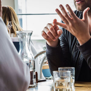 Three young professionals chatting around a cafe table