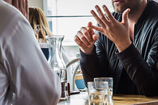 Three young professionals chatting around a cafe table