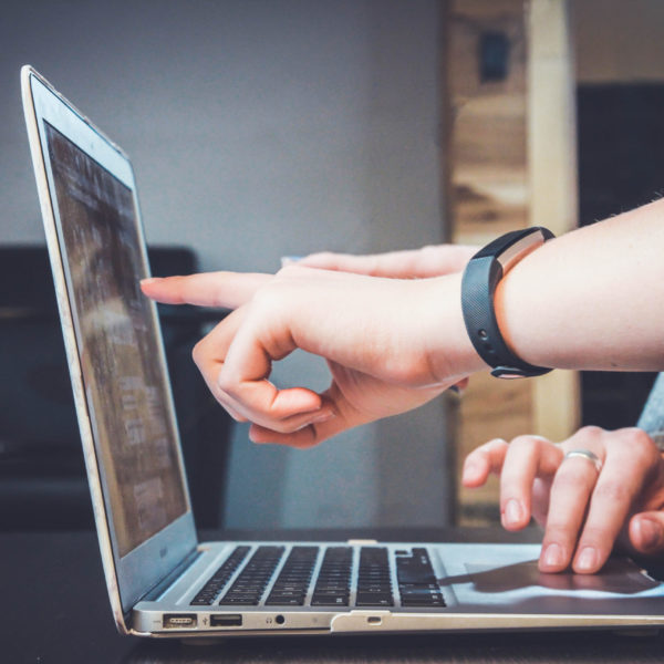 People pointing at a laptop screen