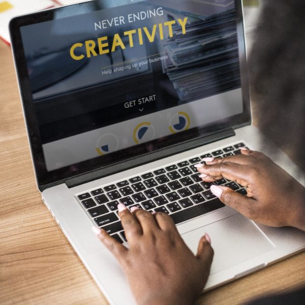 Computer screen with woman typing a presentation on Creativity