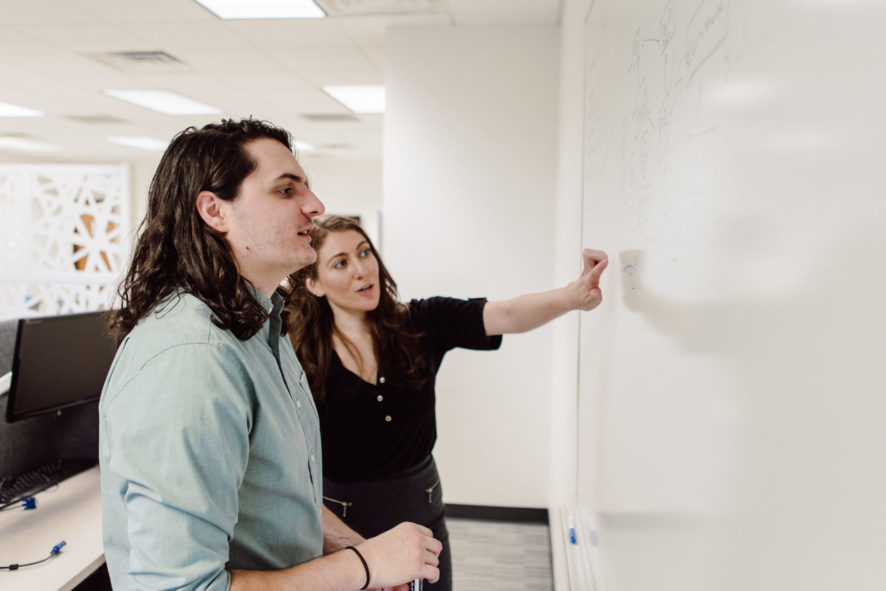 Piccolo team members working on a dry erase board to work on marketing strategies