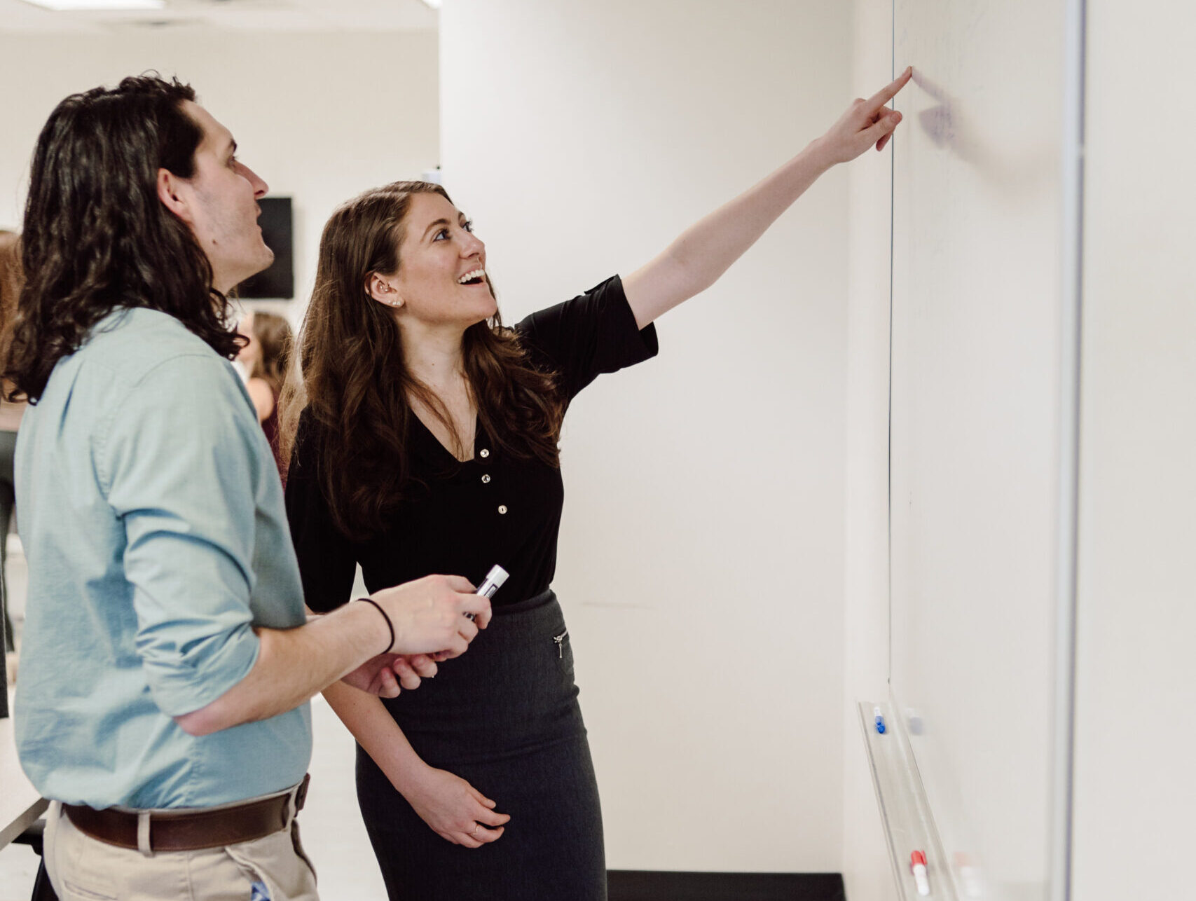 Piccolo team smiling and pointing to a whiteboard