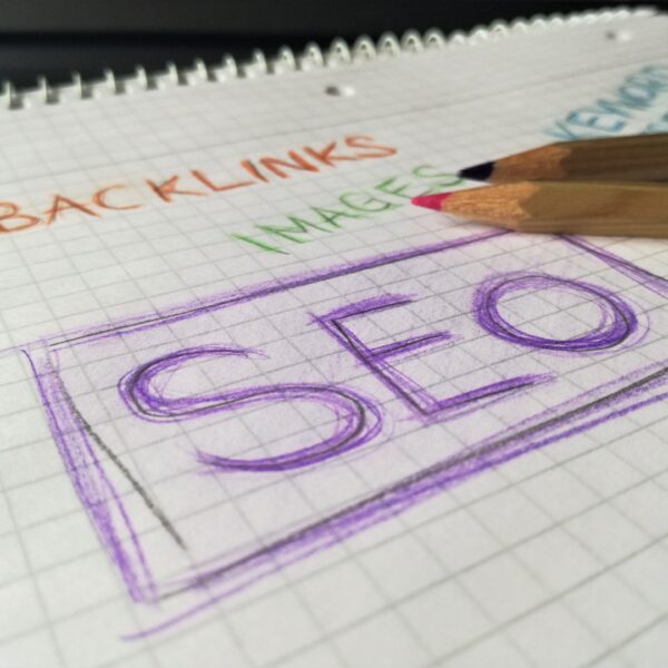 SEO (Search Engine Optimization) written on a piece of paper in purple ink